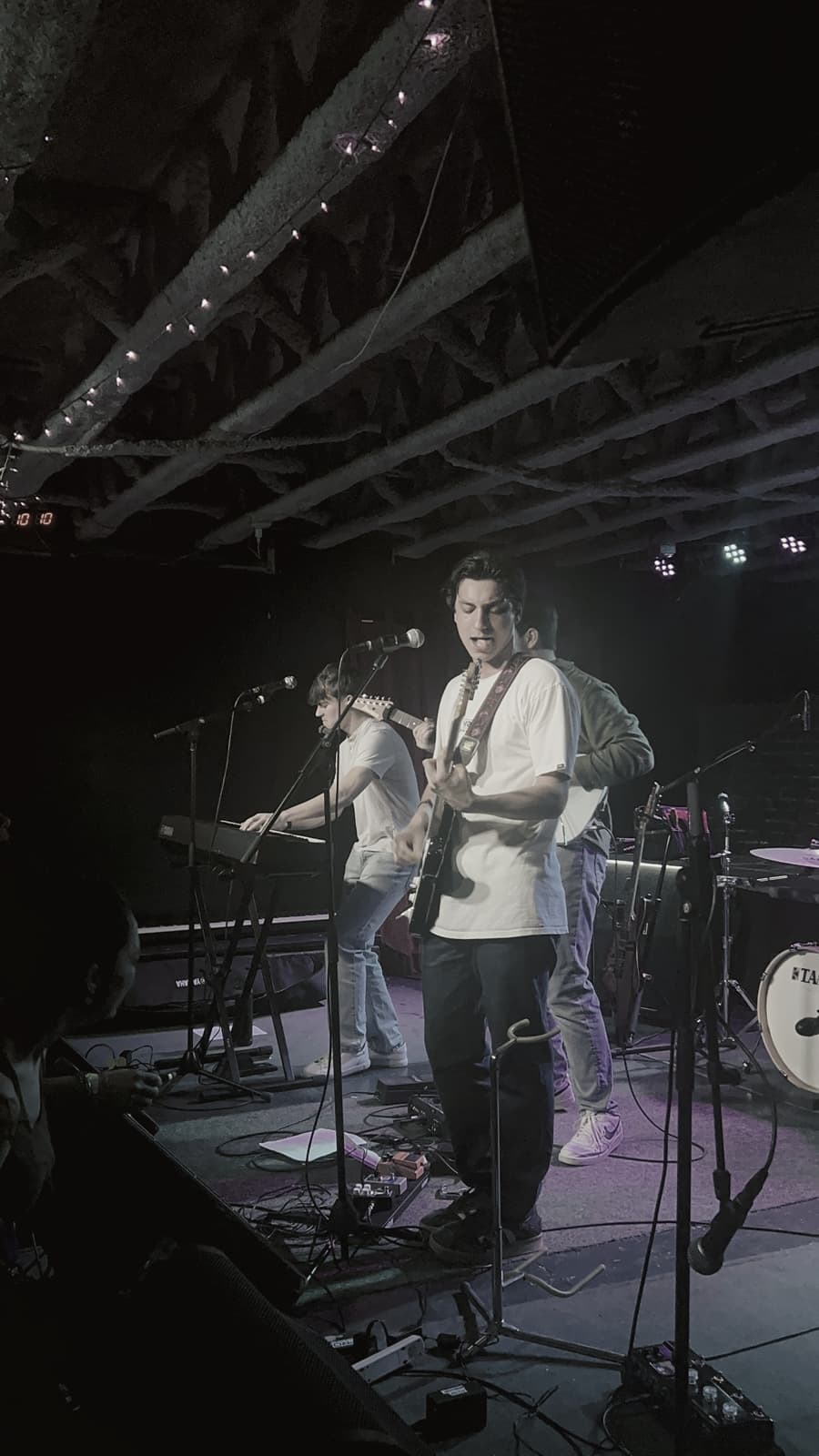 A small-venue stage under purple light